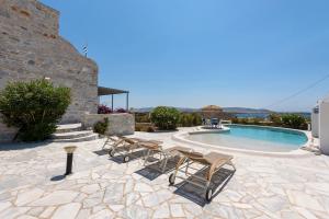 un patio con sedie e una piscina di Aegean Seashell Villa a Pounda