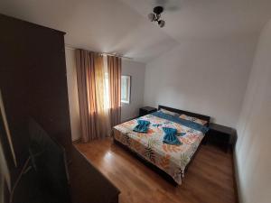 a bedroom with a bed with blue sheets and a window at Varipatti House in Slatina