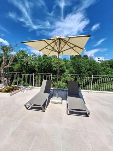 two lounge chairs and an umbrella on a patio at Luxury Villa Breeze with Private Pools in Dassia +70 photos