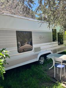 an rv parked in the grass with a table at Caravane en hébergement fixe in Mandelieu-la-Napoule