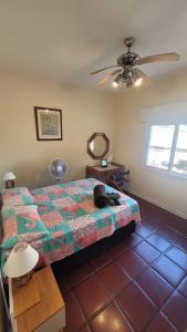 a bedroom with a bed and a ceiling fan at Apê Retrô com Wi-Fi e Vaga - 350 m da Praia da Enseada in Guarujá