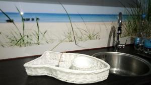 a white basket sitting on a counter next to a sink at Ostseeeule in Graal-Müritz