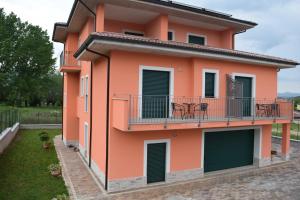 un edificio arancione con balcone e sedie sopra di Villa La Mulinella a Preturo