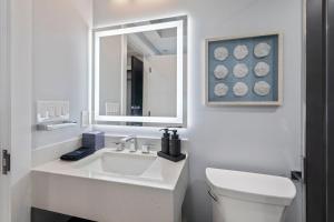 a white bathroom with a sink and a mirror at Ammos Luxury Living- Paros Suite in Ventnor City