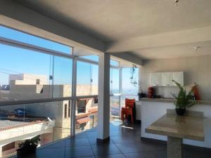 a kitchen and living room with a view of a building at Cristal casa de vidro in São Thomé das Letras