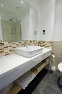 ein Badezimmer mit einem Waschbecken, einem Spiegel und einem WC in der Unterkunft Seacote Hotel in St Bees