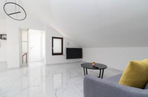 a white living room with a couch and a table at NEW! Apartment in Petrčane 30 meters from the sea - TA Leut Agency in Petrcane