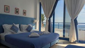 Un dormitorio con una cama con vista al mar. en Coral, en Frangokastello