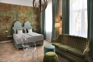 a bedroom with a bed and a couch at Willa Berlińska - pokoje ,restauracja in Kościan