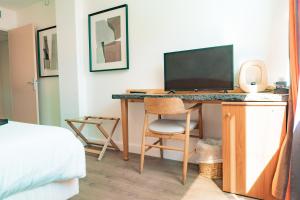 a bedroom with a desk with a computer and a bed at Hôtel Édenia - Spa Estime&Sens in Carnac
