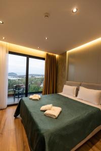 a bedroom with a large bed with two towels on it at Diol Hotel Ksamil in Ksamil +37 photos
