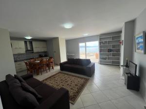 a living room with a couch and a dining room at Pogradec Lakeview Apartament in Pogradec