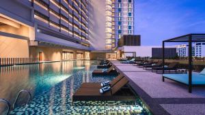 a hotel swimming pool with lounge chairs and a building at Holiday Inn & Suites Penang Prai by IHG in Bukit Mertajam