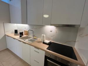 a kitchen with white cabinets and a sink at J&N Living in Spata