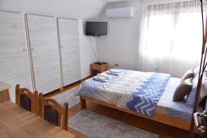 a bedroom with a bed and a tv in it at Apartments Ravno in Plužine