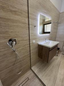 a bathroom with a shower with a sink and a mirror at J&N Living in Spáta