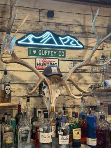 a sign on a wall with bottles of alcohol at 9,000 feet Retreat Above It All in Guffey
