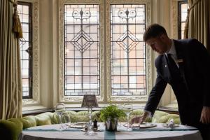 a man in a suit standing in front of a table at Milestone Hotel Kensington in London