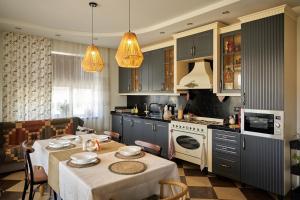 a kitchen with blue cabinets and a table with chairs at Villa Vermont Gusar in Qusar
