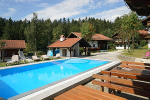 a swimming pool in front of a house at Ferienwohnung PanoramaBlick in Hauzenberg