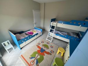 a bedroom with two bunk beds and a ladder at Pogradec Lakeview Apartament in Pogradec
