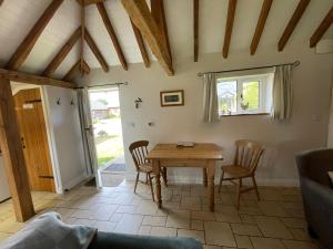 a living room with a wooden table and chairs at Acorns in Plaitford +11 photos
