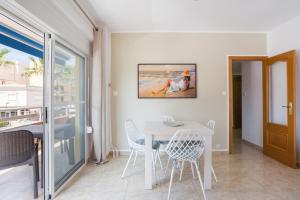 Un comedor blanco con una mesa y sillas. en Daimuz Holidays, en Daimuz