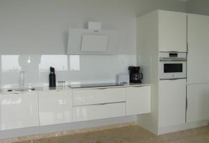 a white kitchen with white cabinets and appliances at Villa Bea ii in Montana la Data