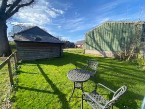 a yard with chairs and a table and a building at Acorns in Plaitford