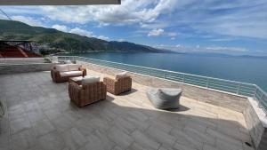 a patio with chairs and a view of the water at LostInPogradec in Pogradec