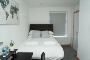 4 Bed Home, with 3 Bathrooms and Free Parking Home for Contractors & Workers- HOLIDAY PROMO FOR CHRISTMAS AND NEW YEAR في مانشستر: غرفة نوم بها سرير أبيض كبير ونافذة +68 صورة