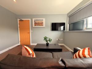 una sala de estar con un sofá y una mesa en Newcastle Quayside Apartment -Sleeps 4 - Parking, en Newcastle