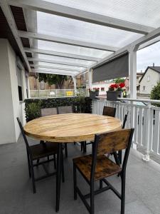 un tavolo e sedie in legno su un patio con tenda da sole di Maison de vacances a Village-Neuf