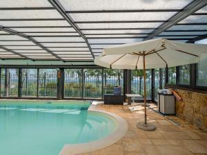 a large swimming pool with an umbrella at Villa Fefi - Liberty d'Artista in Tolentino
