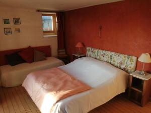 two beds in a room with red walls at Loge & Broc in La Possonnière