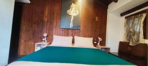 a bedroom with a bed with a green comforter at La Casetta 23 in Perledo