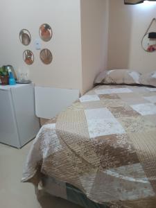 a bedroom with a bed with a quilt on it at Suite das Mangueiras I in Soure