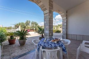 ein Tisch und Stühle auf einer Terrasse mit einem Torbogen in der Unterkunft Villetta Marika - Salento Reservation in Marina di Mancaversa