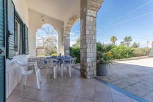 eine Terrasse mit einem Tisch und Stühlen in einem Haus in der Unterkunft Villetta Marika - Salento Reservation in Marina di Mancaversa