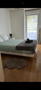 a bedroom with a bed and a rug on the floor at Appartement Cosy in Fresnes