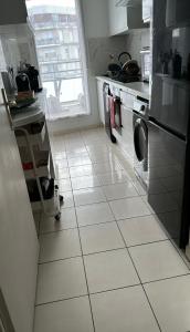 a kitchen with a white tiled floor at Appartement Cosy in Fresnes +1 photo