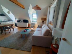 a living room with a white couch and a table at Confort moderne à Sauzon avec vue sur port, accessible PMR, wifi, linge inclus - FR-1-418-184 in Sauzon