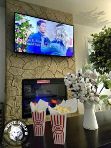 ein Wohnzimmer mit einem TV und einem Tisch mit Popcorn in der Unterkunft WHITE WOLF Farmhouse Retreat in Reidsville