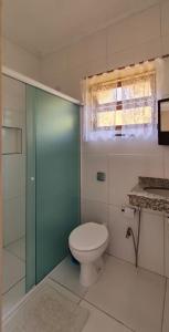 e bagno con servizi igienici e porta doccia in vetro. di Pousada Costa do Sol a Canavieiras