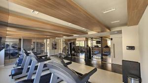 a gym with a bunch of cardio machines in it at Estúdio Moderno em área nobre de Porto Alegre - Conforto e Aconchego em Cada Detalhe in Auxiliadora