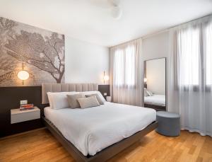 a bedroom with a large bed and a mirror at Biennale Palace R&R in Venice