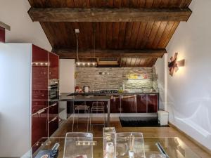 a kitchen with wooden ceilings and a glass table at Villa Fefi - Liberty d'Artista in Tolentino