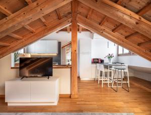 a kitchen and living room with white cabinets and a tv at Biennale Palace R&R in Venice