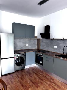a kitchen with a refrigerator and a washer and dryer at La estación in Villafranca del Bierzo