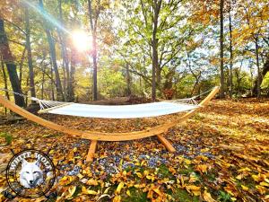 eine Hängematte mitten im Wald in der Unterkunft WHITE WOLF Farmhouse Retreat in Reidsville